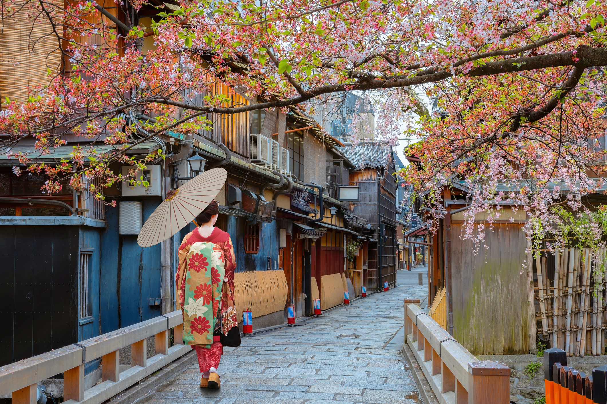 Traditional wooden machiya buildings lining a lantern-lit street in Kyoto's historic Gion geisha district