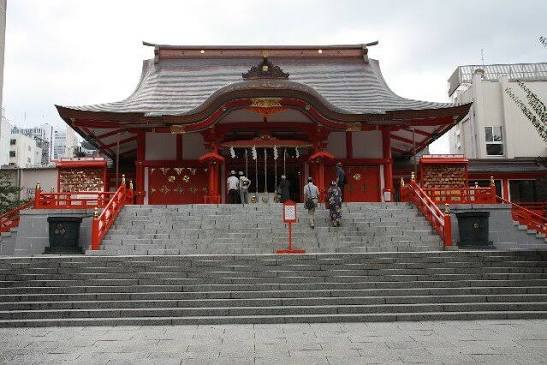 The vermillion torii gates and shrine buildings of Hanazono Shrine tucked beside Shinjuku's nightlife district