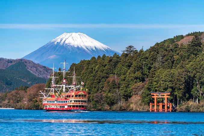 A sightseeing cruise boat crossing Lake Ashi with mountain views in Hakone