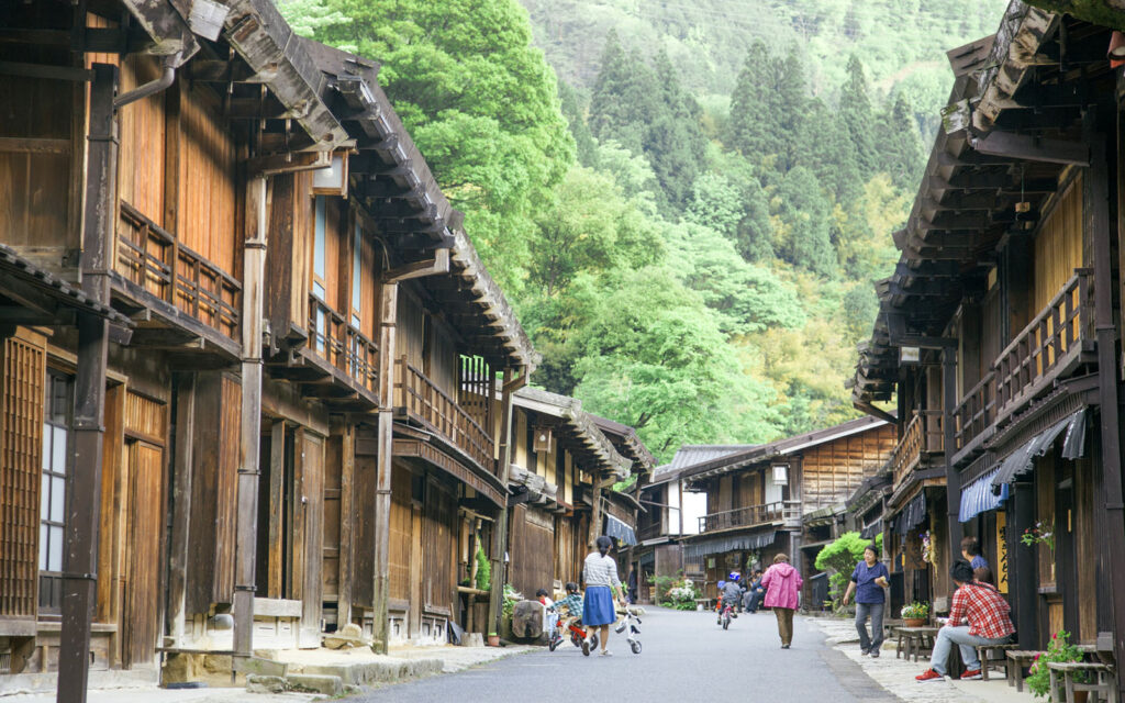 A stone-paved street lined with wooden buildings in the post town of Magome on the Nakasendo trail
