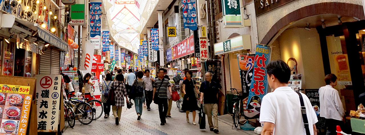 Terry guiding a private tour group down a bustling local neighborhood shotengai shopping street in Tokyo