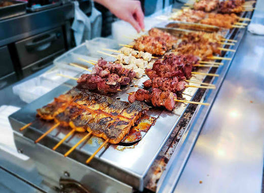 Sizzling chicken yakitori skewers grilling